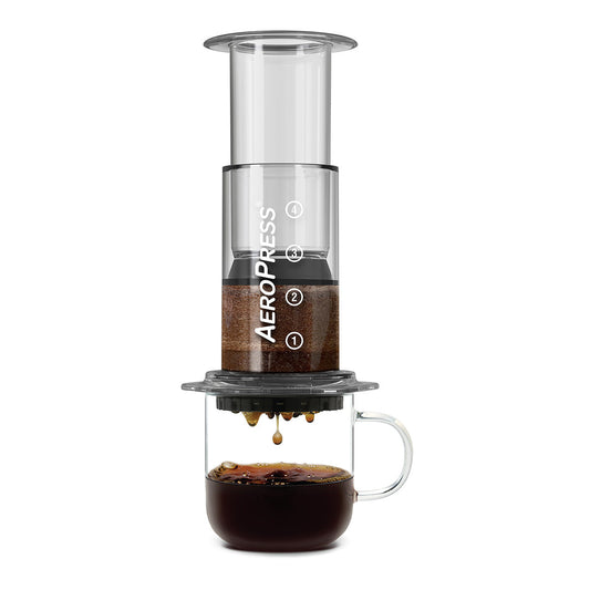AeroPress Clear Coffee Maker in crystal Tritan, 3-in-1 brew tech, brewing coffee into a glass mug.