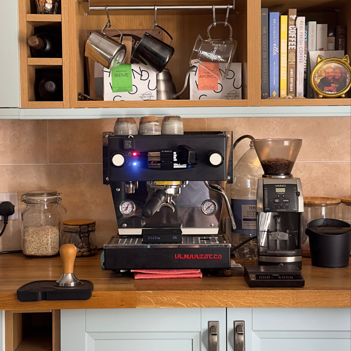 Coffee-making equipment including a coffee machine and grinder on a kitchen counter.